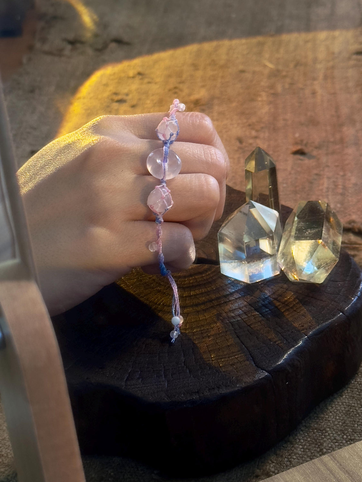 Handwoven rose quartz peace charm bracelet close up
