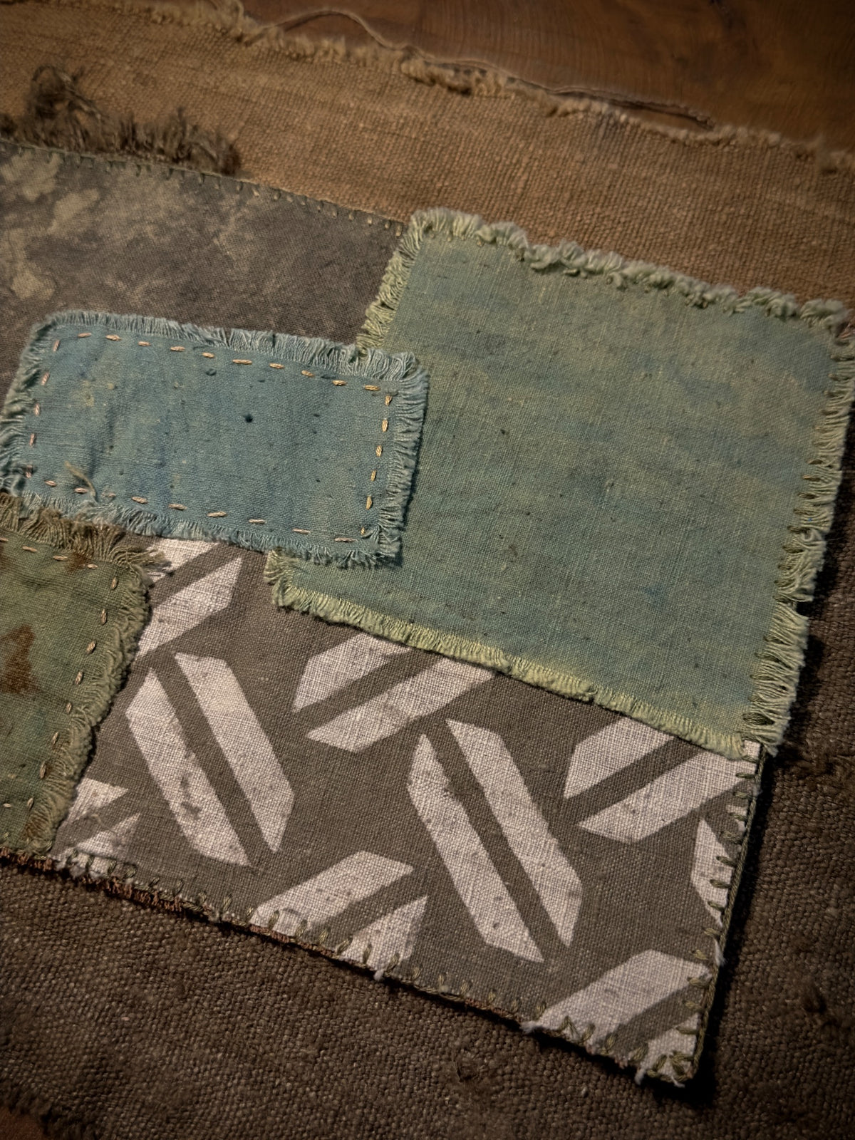 Close-up of muted blue-green plant-dyed patchwork fabric